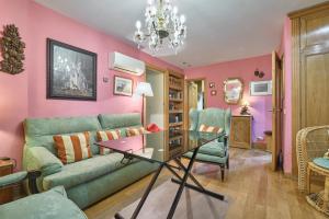 - un salon avec un canapé vert et des murs roses dans l'établissement Apartamentos Carlos, à Madrid