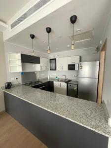a kitchen with a granite counter top and appliances at Premium hotel apartment Aeon towers Sheikh Zayed City in 6th Of October