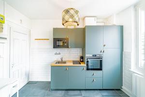 a kitchen with blue cabinets and a sink at Le petit Raspail-Appartement rénové-Gratte-Ciel in Villeurbanne