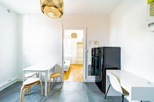 a dining room with a table and a refrigerator at Le petit Raspail-Appartement rénové-Gratte-Ciel in Villeurbanne