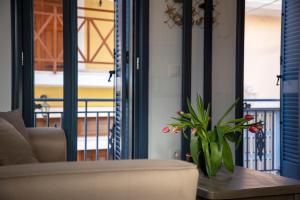 a living room with a couch and a table with a plant at Simo's Apartments in Egina