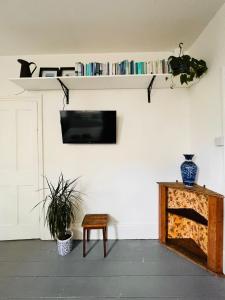 een woonkamer met een tv en een tafel en een bank bij Pretty studio, 2 minutes to beach! Self-contained. in Brighton & Hove