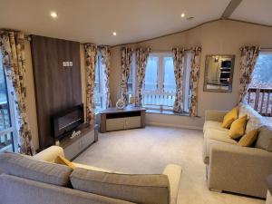 a living room with two couches and a television at Tulip Lodge with Hot Tub in Malton