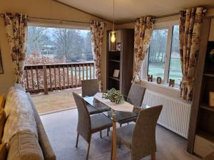 a living room with a couch and a table with chairs at Tulip Lodge with Hot Tub in Malton