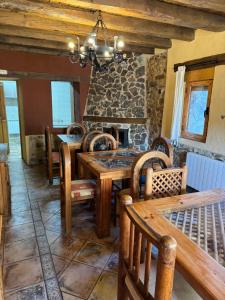 ein Esszimmer mit einem Tisch und einem Steinkamin in der Unterkunft Casa Rural El Medico in Serradilla del Arroyo