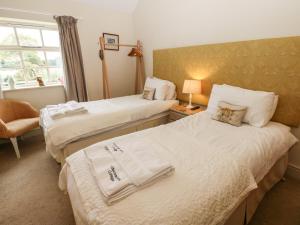 a hotel room with two beds and a window at Brookside Byre in Brancepeth