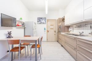 a white kitchen with a table and chairs at Rooftop 2 BDR Apartment with 360-Degree Views in Rome