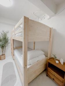 a wooden bunk bed in a room with a table at Nama Hostel Chiangmai in Chiang Mai