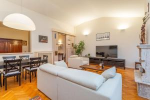a living room with a white couch and a dining room at Rooftop 2 BDR Apartment with 360-Degree Views in Rome