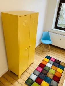 een gele kast en een blauwe stoel in een kamer bij SECRET HIDEAWAYS Design Apartment ARTstudio 5 nahe City l Messe l Hbf in Duisburg