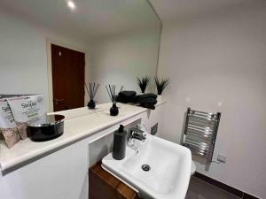 a white bathroom with a sink and a mirror at Liverpool Waterfront Apartment in Liverpool