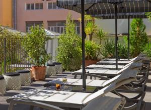 a row of tables with umbrellas on a patio at H10 Metropolitan 4* Sup in Barcelona