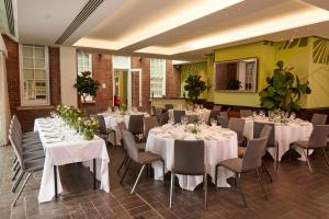 a room with white tables and chairs with flowers on them at Hotel du Vin Exeter in Exeter