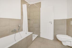 une salle de bain avec une baignoire, des toilettes et un lavabo dans l'établissement Stilvoller Bungalow in Selm-Cappenberg, à Selm