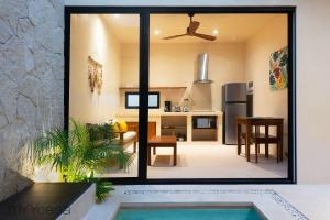 Una cocina y un comedor con vista a una sala de estar. en Casa Yaakun, en Tulum