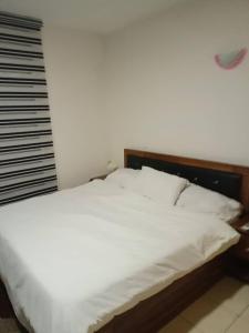 - une chambre avec un lit doté de draps blancs et une fenêtre dans l'établissement 2 bedroom apartment at 1004 Estate, à Lagos
