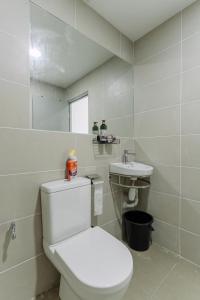 a white bathroom with a toilet and a sink at SUMMER SUITES APARTMENT CASETTA HOMESTAY 1 at Kota Samaraham Kuching in Kota Samarahan