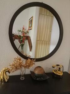 un miroir au-dessus d'une table avec un vase dans l'établissement 2 bedroom apartment at 1004 Estate, à Lagos