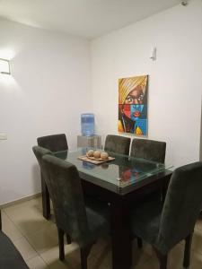 a dining room table with chairs and a painting on the wall at 2 bedroom apartment at 1004 Estate in Lagos