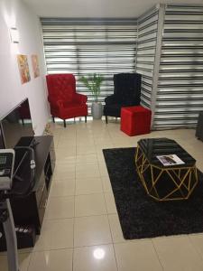 - un salon avec deux chaises et un fauteuil rouge dans l'établissement 2 bedroom apartment at 1004 Estate, à Lagos