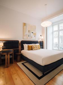 - une chambre avec un grand lit et une tête de lit noire dans l'établissement Ando Living - Madalena Townhouse, à Lisbonne