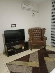 un salon avec une chaise et une télévision dans l'établissement 2 bedroom apartment at 1004 Estate, à Lagos