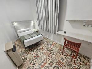 a small room with a bed and a chair at Casa de Huéspedes Almansa in Madrid