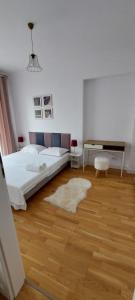 Un dormitorio blanco con una cama y un escritorio. en Luxury new apartament private parking, en Bucarest