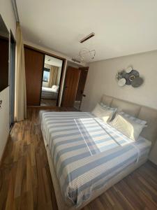 a bedroom with a large bed with a striped blanket at Appartement neuf meublé entièrement à louer in Casablanca