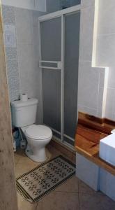 a bathroom with a toilet and a shower at Hostal Yaku Montañita in Montañita