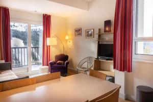 a living room with a couch and a table and a tv at Flaine- Appartement 7 personnes in Flaine