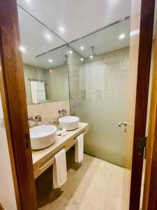 a bathroom with two sinks and a large mirror at Castelo Hotel in Chaves