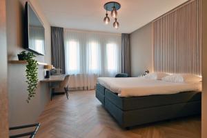 a bedroom with a bed and a desk in a room at Hotel Alkmaar - Bar & Restaurant in Alkmaar +75 photos
