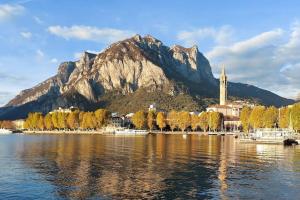 a mountain with a town and a body of water at a mio agio apartment in Lecco