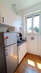 a kitchen with a white refrigerator and a window at a mio agio apartment in Lecco