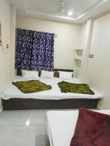 a bedroom with two beds and a blue curtain at Hotel star villa INN in Ujjain +18 photos
