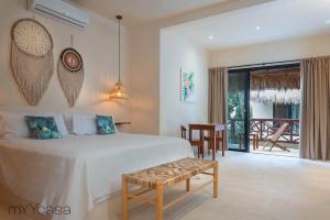 Un dormitorio con una cama y una mesa y un balcón. en Casa Yaakun, en Tulum 37 fotos más