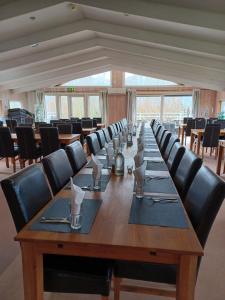 a long wooden table with black chairs around it at Vandrarhem & Lofthus Solstickan Mellbystrand in Mellbystrand