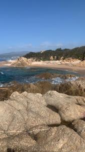 uma praia com pedras e o oceano e uma praia em Camping car fixe dans la campagne em Pianottoli-Caldarello
