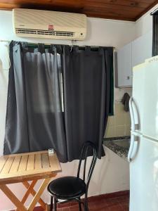 einen schwarzen Vorhang in einer Küche mit einem Tisch und einem Stuhl in der Unterkunft Monoambiente F en Ctes Cap in Corrientes