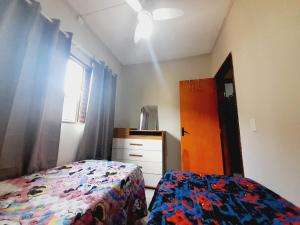 a bedroom with a bed and a dresser and a window at APARTAMENTO - 2 quartos in Campo Grande