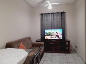a living room with a television and a couch at 2 quartos com ar - Apto em condomínio in Campo Grande