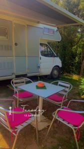 uma mesa e cadeiras em frente a uma caravana em Camping car fixe dans la campagne em Pianottoli-Caldarello