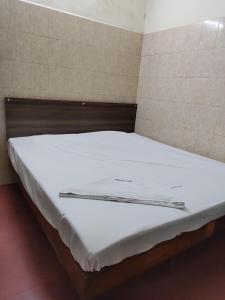 Bett in einem Zimmer mit weißer Bettwäsche in der Unterkunft Jeyanthi Tower Vellore in Vellore