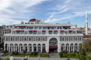a large white building with a mosque in the background at Le Port Boutique Apart Hotel in Batumi