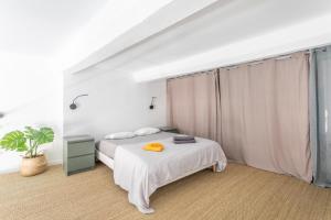 um quarto branco com uma cama e uma janela em Duplex lumineux centre ville em Aix-en-Provence