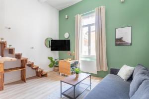 uma sala de estar com um sofá azul e uma janela em Duplex lumineux centre ville em Aix-en-Provence