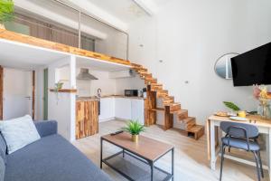 uma sala de estar com um sofá azul e uma cozinha em Duplex lumineux centre ville em Aix-en-Provence