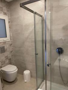 W łazience znajduje się toaleta i przeszklony prysznic. w obiekcie Luxueux appart à 5 min de l'aéroport w mieście La Soukra