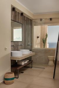 a bathroom with two sinks and a mirror at Apolis Villas & Suites Resort in Parga